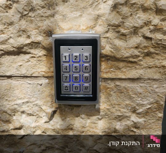 קודן מתכתי מוארת בתאורה כחולה מותקן על קיר אבן